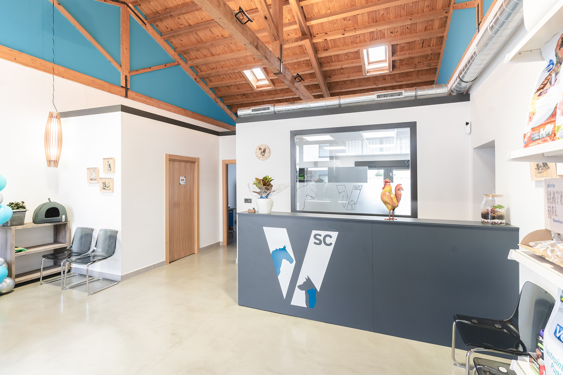 Vista del mostrador de recepción en color gris oscuro con el logo de la clínica en blanco